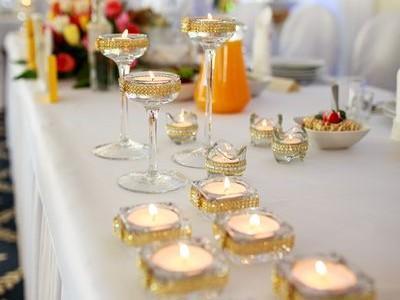 Zastawa weselna z palącymi się świeczkami na stole 1